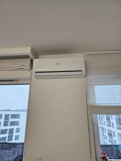 Technik montujący klimatyzator na ścianie